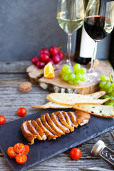 Fototapeta na wymiar Wine snack set. Glass of red and white wine, grape, cheese, over rustic wooden background.