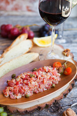 Wine snack set. Glass of red  wine, grape, cheese, over rustic wooden background.