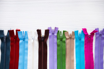 Tailor: colorful and many zipper for tailoring, sewing on wood background