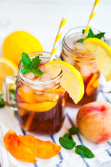Homemade lemonade with ripe  peaches and fresh mint. Fresh peach ice tea on white wood table. Copy space background.