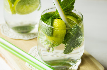 Fresh organic lemonade with lemon and mint leaves on a light background. Selective focus. Horizontal.