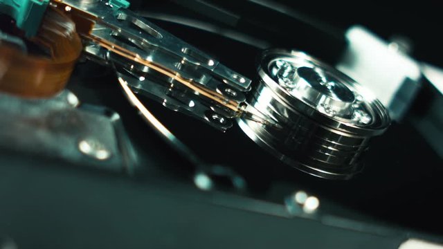 Hard Disk Drive Close-Up Details. HDD head working on rotating magnetic surface. Hard Disk Drive is a data storage device used for storing and retrieving digital information using rotating platters