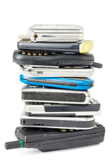 stacked of old and obsolete mobile phone on white