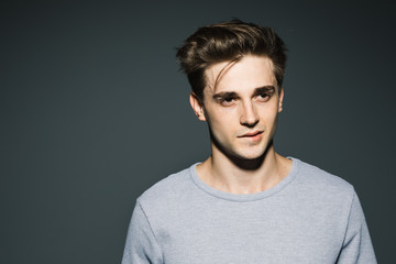 Handsome in style. Cheerful young man in smart casual wear while standing against grey background
