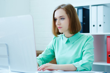 Beautiful young businesswoman working  on a computer in the office. Business, exchange market, job offer, analytics research, excellent education, certified public accountant concept