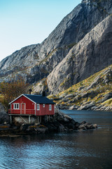 Fototapeta na wymiar Lofoten islands is an archipelago in the county of Nordland, Norway. Distinctive scenery with dramatic mountains and peaks, open sea and sheltered bays and red fishing huts, called rorbu.