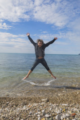 Joyful jumping against the sea