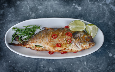 grilled fish with chilli and green garnish