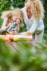 Mother help daugther rub apples