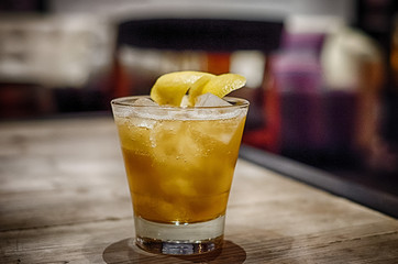 yellow cocktail on wooden table