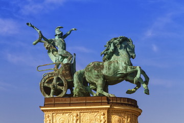 Statue representing War, a man holding a snake on a chariot, on a colonnade in Heroes Square or Hosok Tere, Budapest, Hungary.