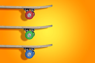 View of the three skateboards on an orange background