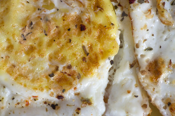 Closeup of fried eggs with seasoning. Delicious and healthy breakfast.