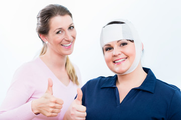 Teilnehmer im Erste-Hilfe-Kurs nach erfolgreichem Anlegen eines Kopfverbandes 