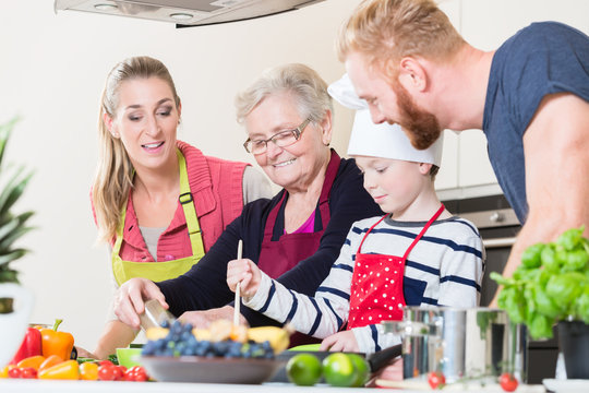 Family cooking in multigenerational household with son, mother, father and grandfather