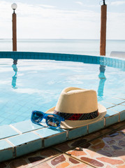 Obraz premium Image of hat and sunglasses by pool