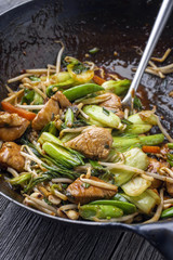 Traditional stir fried Chicken Gung Bao with Vegetable as close-up in Wok