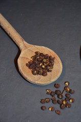Pfeffer als Korn auf Kochlöffel aus Holz