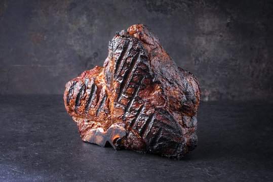 Barbecue dry aged Wagyu Porterhouse Steak as close-up on a black slate