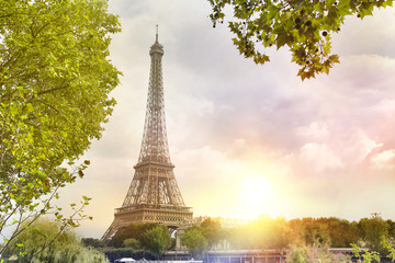 Fototapeta na wymiar Eiffel tower sunset with clouds. Romantic sunset background. Old Monument with boats on Seine river in Paris, France.