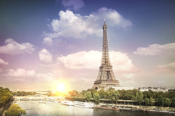 Eiffel tower sunset with clouds. Romantic sunset background. Old Monument with boats on Seine river in Paris, France.