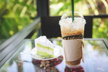 Iced coffee with coconut cheese cake on the table in cafe coffee shop