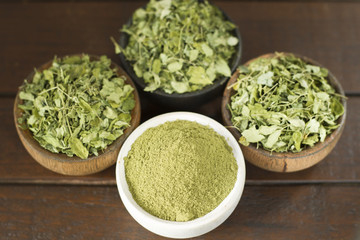 Leaves and moringa powder on wood (moringa longa)