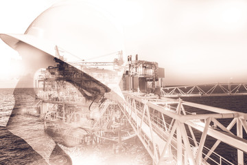 Double exposure of Engineer or Technician man with safety helmet operated platform or plant by using tablet with offshore oil and gas platform background for oil and gas business concept