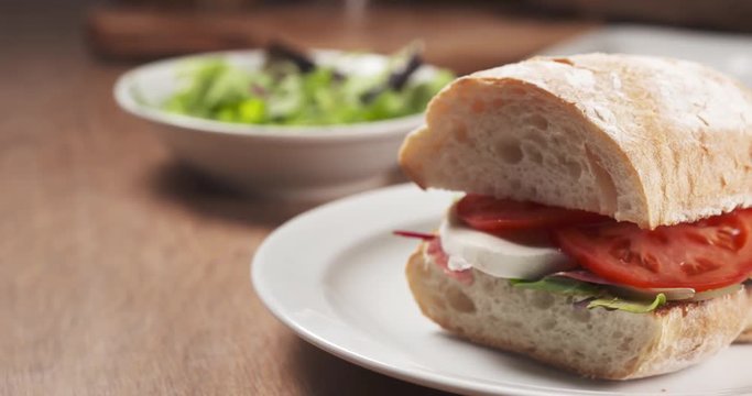 Slide shot of ciabatta sandwich with speck, mazzarella and vegetables, 4k 60fps prores footage