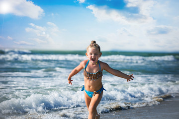 Three year old girl running to the sea