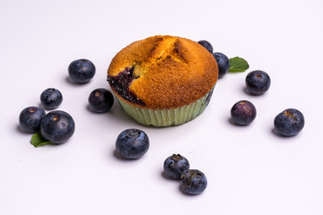 Blueberry muffins and blueberries on wooden background