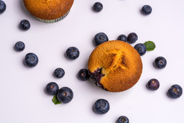 Blueberry muffins and blueberries from above on wooden background