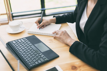 Business woman working on desk with laptop computer,Business woman using pen for note to do list concept.