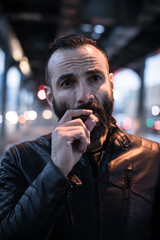 A closeup portrait of a middle aged, Egyptian man smoking alone in the streets of Brooklyn, New York. Shot using ambient light during the spring of 2017.