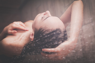 Young beautyful woman under shower in bathroom