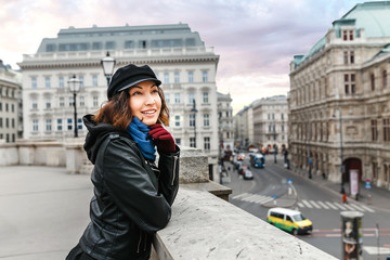 Naklejka premium Young Asian woman tourist on the street in the center of Vienna smiling at winter