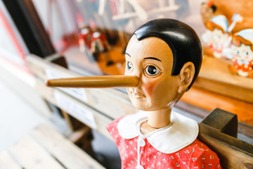 wooden pinocchio dolls with his long nose at the souvenir shop