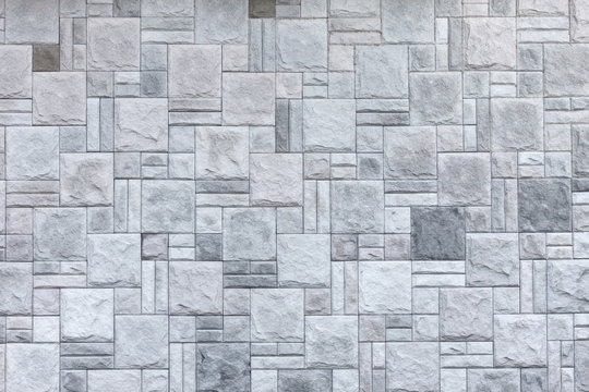 The wall is faced with light-grey decorative stone