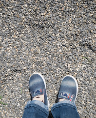 Children's legs on a gravel background