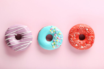 Tasty donuts with sprinkles on paper background