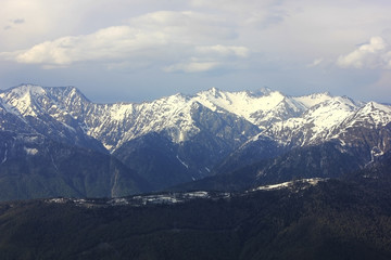 Mountain landscape. Mountain chain with snowy peaks. Mountain valley in cloudy weather. Sochi, Russia.