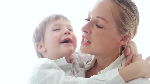 mother and son sitting at home exciting in white clothes