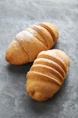 Fresh croissants on grey wooden table