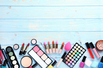 Different makeup cosmetics on blue wooden table