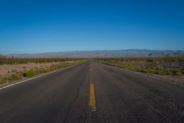 Fototapeta na wymiar Long straightaway on a highway in the desert 