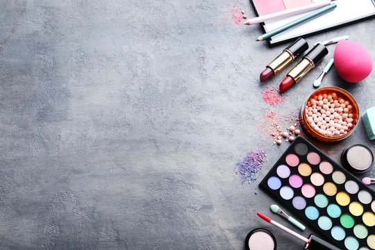 Different makeup cosmetics on grey wooden table