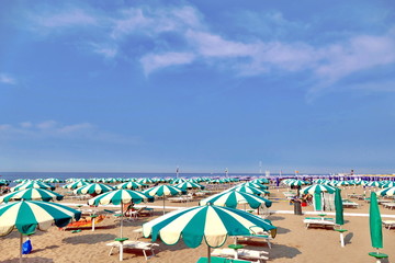 Beach with green umbrellas in summer time
