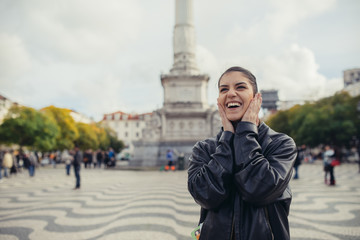 Naklejka premium xcited woman looking surprised and amazed,smiling,looking up.Young tourist backpacker woman excited,overwhelmed,looking at something amazing on her trip.Traveling on beautiful places.Admiring