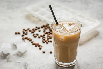 coffee ice cubes and beans with latte on stone desk background