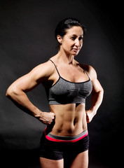 Fototapeta na wymiar Muscular bodybuilder woman showing her muscles.